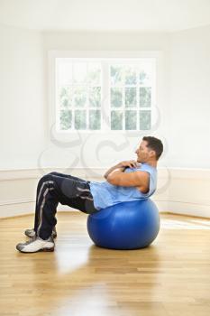 Royalty Free Photo of a Man Doing Sit Ups on a Balance Ball