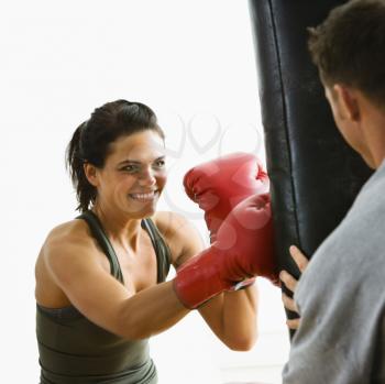 Royalty Free Photo of a Female Boxing Hitting a Punching Bag