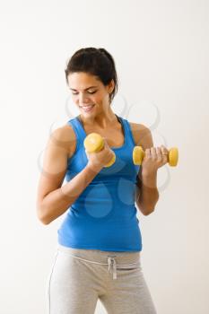 Royalty Free Photo of a Woman Lifting Hand Weights and Smiling