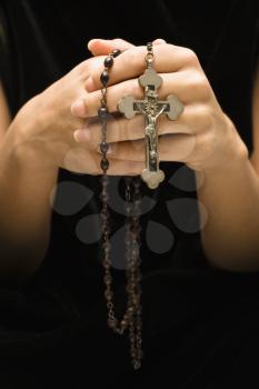 Royalty Free Photo of a Woman Holding a Rosary With a Crucifix