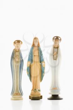 Virgin Mary statue with hands held out with angelic figures on each side against white background.