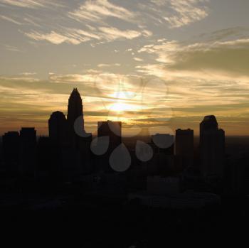 Sunset silhouetting aerial view of Charlotte, North Carolina city skyline.
