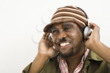 Royalty Free Photo of a Man Wearing a Knit Hat and Listening to Headphones Smiling