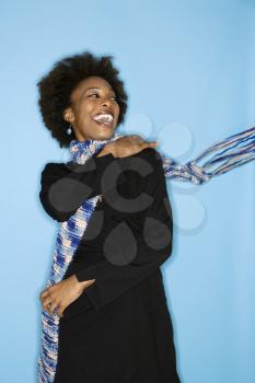 Royalty Free Photo of a Smiling Woman Flinging a Scarf Over Her Shoulder