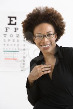 Royalty Free Photo of a Woman Wearing Eyeglasses With a Medical Eye Chart in the Background