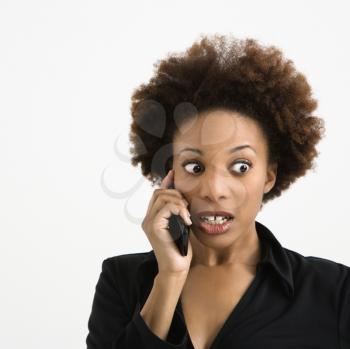 Royalty Free Photo of a Woman Talking on a Cellphone Looking Shocked