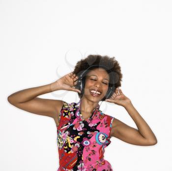 Royalty Free Photo of a Woman Listening to Headphones Smiling and Dancing