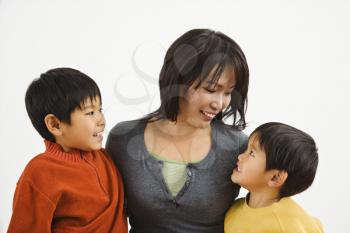Royalty Free Photo of a Mother and Two Sons Smiling at Each Other