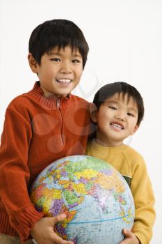 Royalty Free Photo of Two Boys Holding a World Globe and Smiling