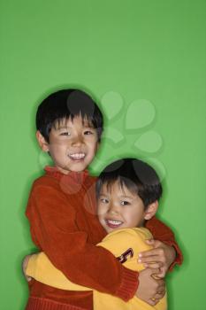 Royalty Free Photo of Young Brothers Hugging Each Other and Smiling