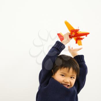 Royalty Free Photo of a Young Boy Playing with a Plastic Toy Airplane