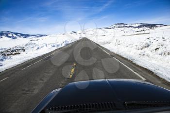 Royalty Free Photo of a Car Driving Down a Road in Snowy Colorado During Winter