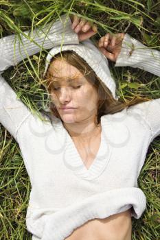 Royalty Free Photo of a Redheaded Woman Lying in the Grass Resting