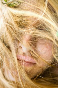 Royalty Free Photo of a Close-up Portrait of a Woman With Windblown Hair Covering Face