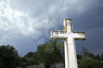 Royalty Free Photo of a Cross in the Graveyard Against Stormy Clouds in the Sky
