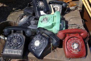 Royalty Free Photo of a Stack of Old Broken Rotary Telephones on a Table
