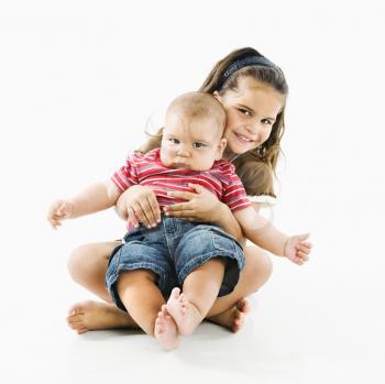 Royalty Free Photo of a Little Girl Holding Her Baby Brother in Her Lap
