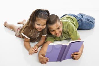 Royalty Free Photo of a Brother and Sister Reading a Book Together
