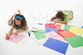 Royalty Free Photo of a Young Boy and Girl Coloring on Construction Paper and Smiling