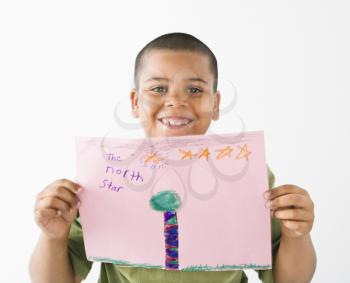 Young boy proudly showing drawing.