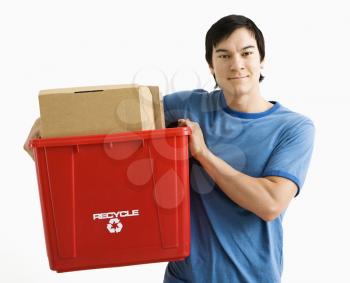 Portrait of Asian young man standing holding recycling bin.