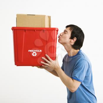Royalty Free Photo of a Man Standing Kissing a Recycling Bin