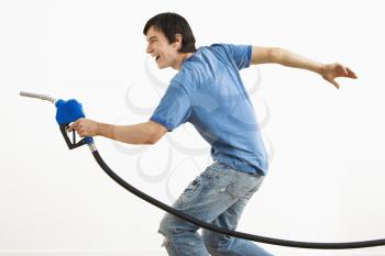 Royalty Free Photo of a Man Aiming Gasoline Pump Nozzle Like a Gun