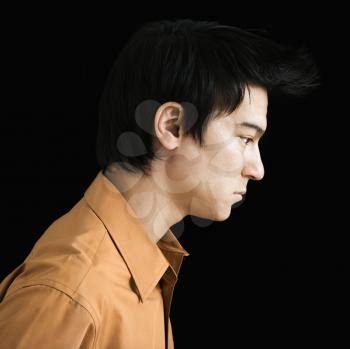 Side profile of serious Asian young man.