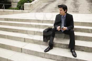 Royalty Free Photo of a Businessman Sitting on Steps in an Urban area