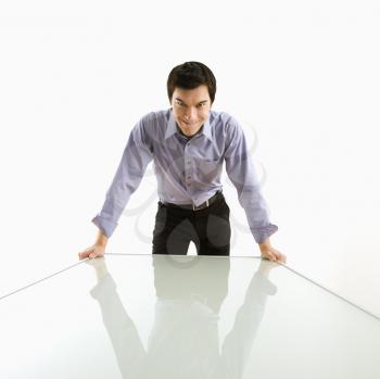 Royalty Free Photo of a Businessman Standing Over a Conference Table With a Devilish Grin