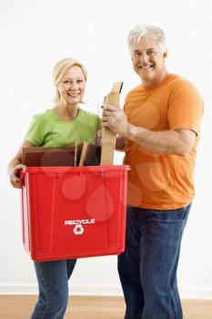 Royalty Free Photo of a Man and Woman Smiling While Holding a Recycling Bin