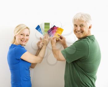 Royalty Free Photo of a Middle-Aged Couple Comparing Paint Swatches