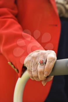 Close-up of an elderly woman's hand on her walker.  Vertical shot.