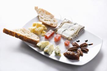 Appetizer tray with selection of breads, cheeses, fruits and nuts. Horizontal shot.