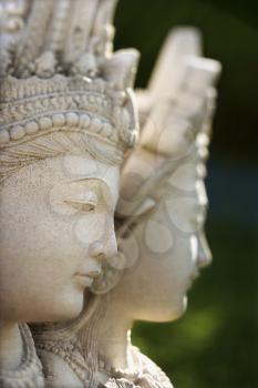 Carved stone statue of the Buddhist Goddess Kuan Yin. Vertical shot.