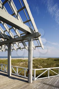 View of ocean and grassy dunes from arbor deck.  Vertically framed shot.