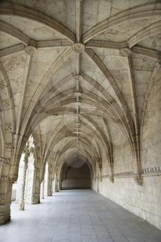 Arched exterior hallway of the Monastery of Jeronimos in Lisbon, Portugal. Vertical shot.