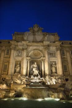 Trevi Fountain at night with lights under the water lighting the statuary. Vertical shot.