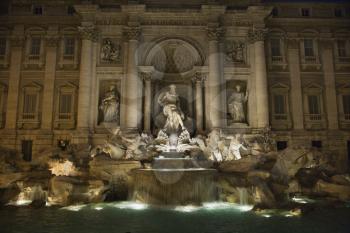 Trevi Fountain at night with lights under the water lighting the statuary. Horizontal shot.
