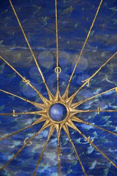 Blue compass rose set against a water motif. Vertical shot.