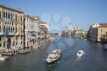 Boats on a canal surrounded by old world buildings in Venice, Italy. Horizontal shot.