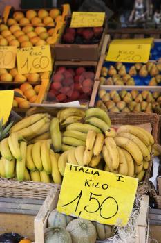 Boxes of bananas and other fruits at a market in Italy. Vertical shot.
