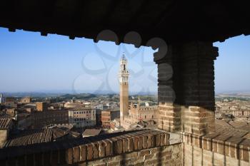 High angle view of Piazza del Campo and surrounding buildings in Siena, Italy, seen from a covered rooftop vantage point. Horizontal shot.