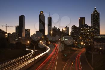 Cars on a freeway traveling through downtown at night. Horizontal shot.
