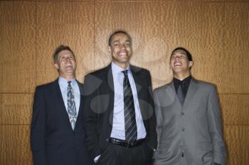 Businessmen of ethnic diversity standing together smiling and laughing. Horizontal shot.