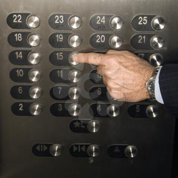 Caucasian man's hand pushes the elevator button to the fifteenth floor. Square shot.