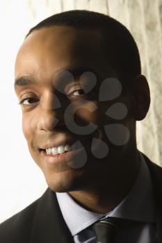 Head and shoulder portrait of smiling African-American mid-adult businessman.