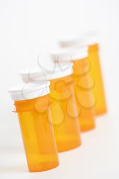 Yellow medicine bottles lined up in a row. Vertical shot. Isolated on white.