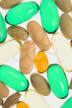 Overview of different color and size vitamin supplement pills. Vertical shot.