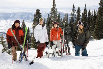 Portrait of group of skiers standing on ski slope in Colorado smiling with a valley in background